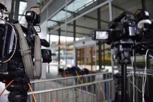 Câmeras de TV em tripés apontadas para local de coletiva de imprensa