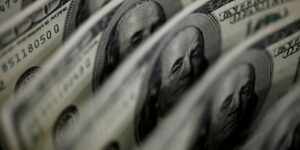 Notas de cem dólares dispostas lado a lado em close