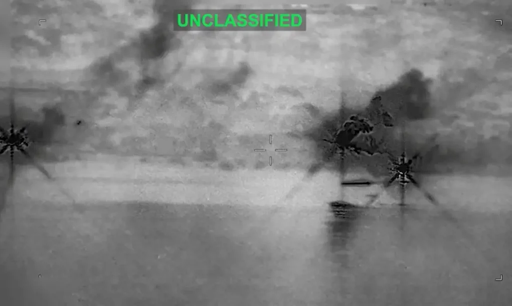 Imagem em preto e branco de mira militar mostra fumaça de explosões em instalação