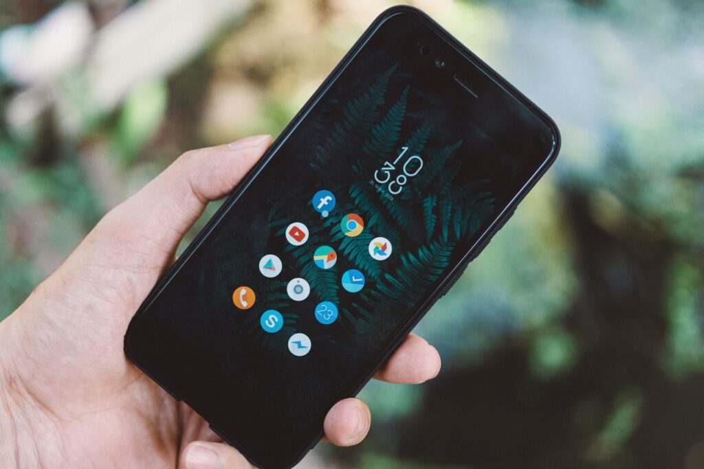 Mão segurando celular com aplicativos