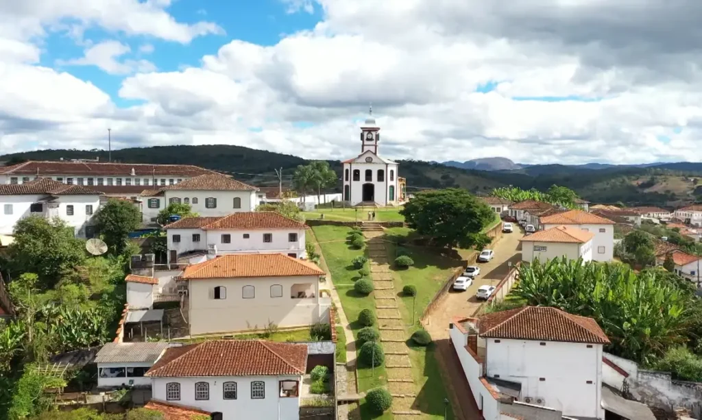 Vista aérea de igreja histórica cercada por casarões coloniais em cidade mineira